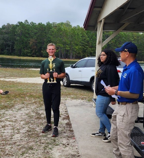 Cadet Mathew Sletto holds his third-place trophy for orange course during the orienteering meet.
